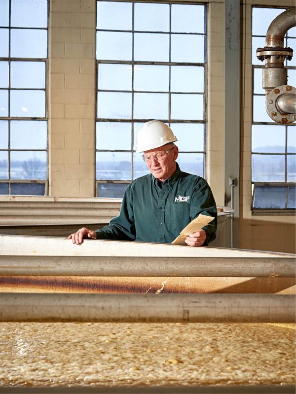 Master Distiller Greg Metze checks a tank full of fermenting mash