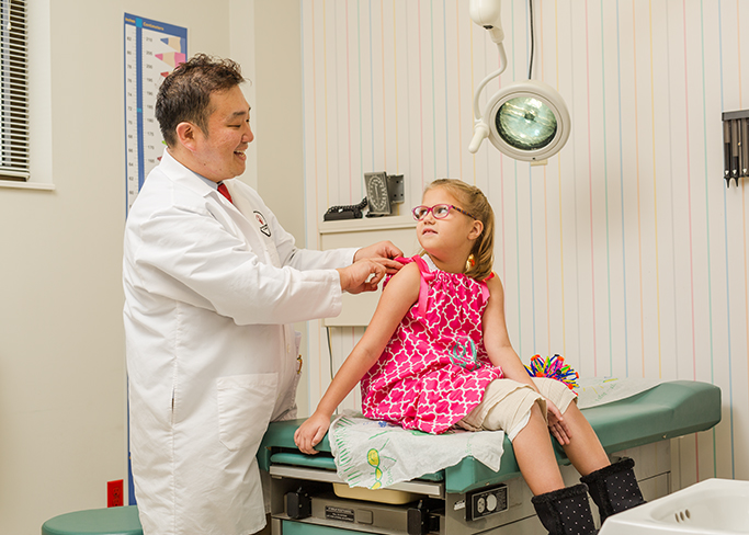 Philip Chang, M.D., examines patient Sadie Lee at Shriners Hospital for Children.